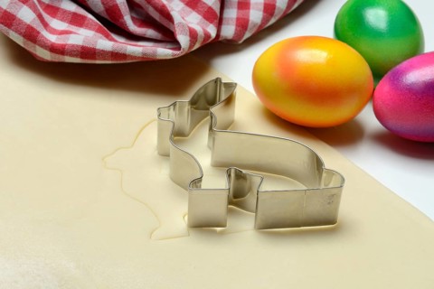 Rolled dough with bunny cookie cutter and easter eggs