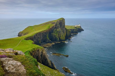 A cliff coast with a lighthouse overlooking the vast blue sea, Neist Point Lighthouse, Waterstein,