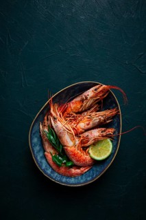 Langoustines, Australian, freshly frozen on ice, top view, lime and greens