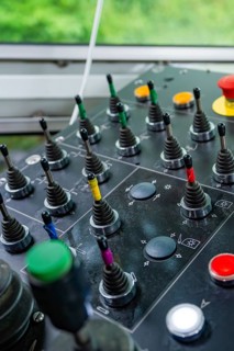 Control panel with levers and coloured buttons in front of a window front, Hermann Hesse Bahn track