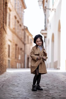 A stylish young girl stands confidently in a picturesque, cobbled street of Civitanova, Italy,