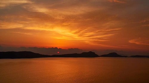 A bright orange sunset, clouds can be seen on the horizon, Navarino Bay, Pylos, Peloponnese, Greece