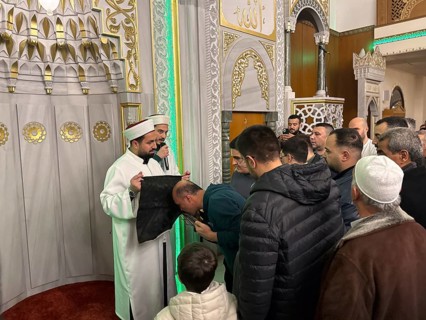 Dozens of Muslims stand in a long queue to view a sacred piece of the Kaaba curtain (Kiswa) while