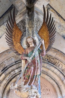 Archangel Michael at the entrance to the portal of the parish church of St. Michael. City view of