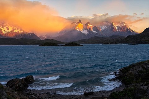 Cuernos del Paine in morning light, clouds over snowy peaks, windswept Lake Pehoé with waves in the