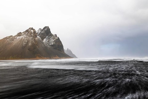 Sea waves on lava sandy beach against mountain backdrop, sea, snow, winter, Stokksnes, Vestrahorn,