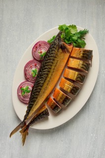 Smoked mackerel, top view, with spices, on a wooden table, no people, selective focus