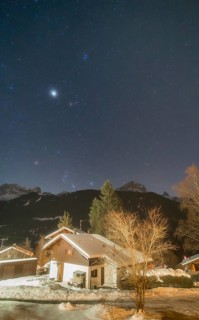 A starry night sky showcases the constellations of Orion and Taurus, along with Jupiter, the