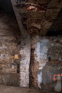 Exposed brick and concrete wall featuring signs of ongoing construction. Visible repairs highlight