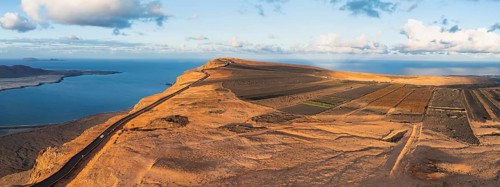 Road on cliffs in evening light, steep cliffs on the coast near Mirador del Porrito, aerial view,