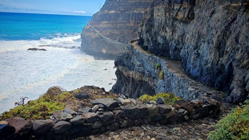Narrow stone trail, volcanic stone hiking trail along high cliffs with sea views, hiking, Marinha