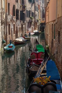 Gondolas on a narrow waterway surrounded by historic buildings and a peaceful atmosphere, Venice,