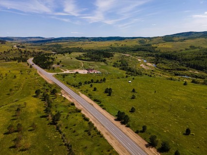 A vast expanse of green fields stretches across the landscape in Vladivostok, Russia. Winding roads