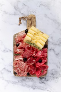 Assorted meat, appetizer, prosciutto, salami and ham, with maasdam cheese and olives, on a wooden