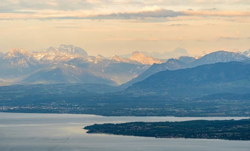 A breathtaking aerial photograph captures the serene beauty of Lake Leman with the majestic Alps in
