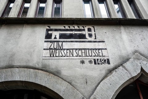 Historic sgraffito on a house façade with the motif of a white key and the date 1482 in the