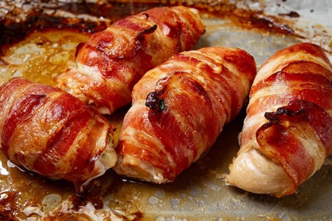 Baked chicken breast, wrapped in bacon, on a baking tray. in the home kitchen.close-up