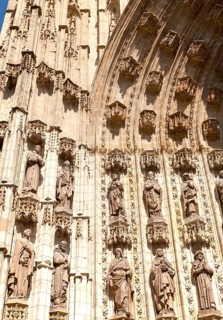 Detail of carved stonework of cathedral frontage showing statues of saints, Seville, Spain