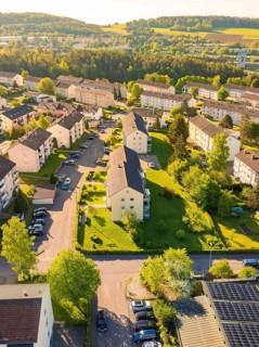Aerial view of a housing estate with apartment blocks surrounded by hills and green nature, Calw,