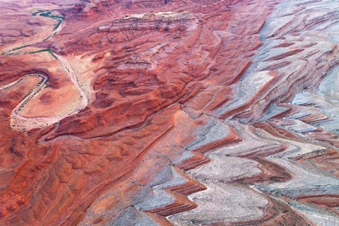 Captivating aerial shot of the San Juan River gracefully meandering through the vibrant red