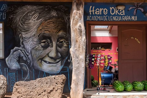 Wall painting with portrait of an elderly smiling woman on the façade of the language school Hare