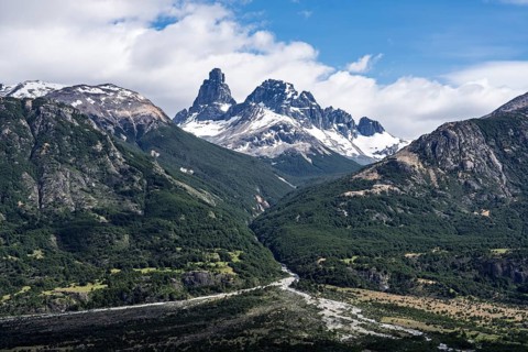 Cerro Palo with snow-covered cliffs, wooded mountain slopes and river valley in the foreground,