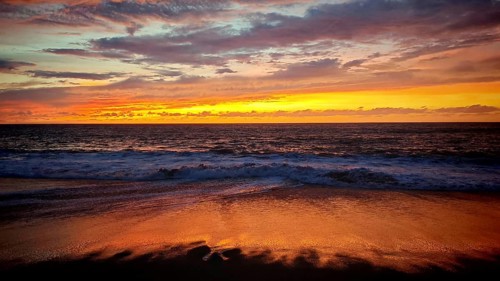 Romantic sunset over gentle waves on the beach, the sky glows in warm colors, Tarrafal de Monte