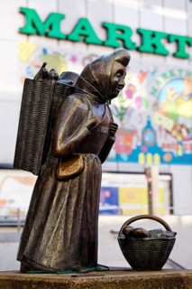 The bronze sculpture Kiepenfrau by Hans-Jürgen Zimmemann shows Karoline Duhnsen in front of the