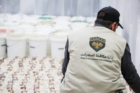 Personnel from the Syrian Anti-Narcotics Directorate display a massive cache of confiscated illegal