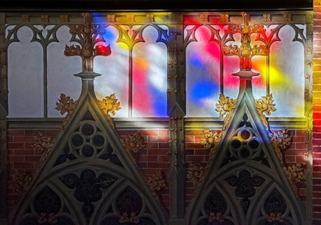 Colored light falls through the stained glass windows in St. Anthony's Church onto a sacred wall