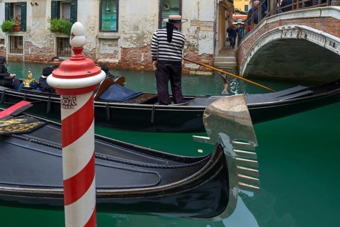 Gondola ride with tourists through the old town of Venice, Veneto, Italy