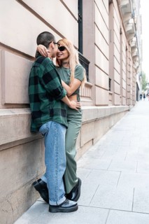 A Colombian lesbian couple lovingly embraces against a city wall, symbolizing pride, identity, and