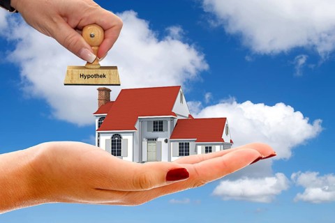 Hand with single-family house, cumulus clouds, blue sky, spring in northern Germany, dream home,