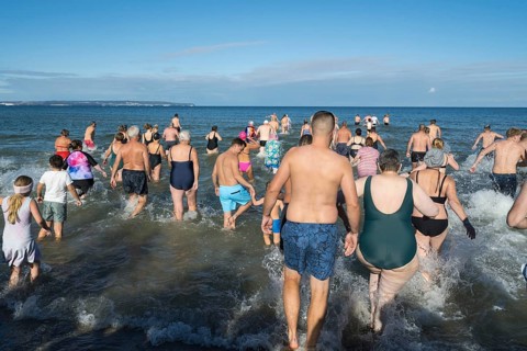 Swimmers run into water to bathe, tourist attraction Binzer Abbaden, Binz, seaside resort, Rügen