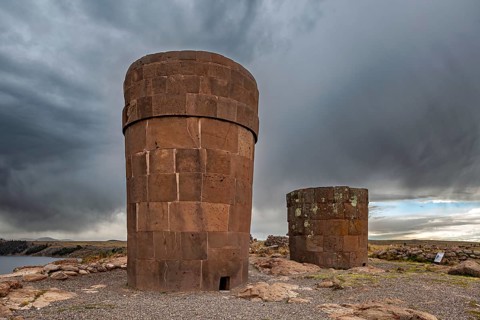 Two massive stone towers surrounded by grey skies and barren landscape, The Chullpas of Sillustani