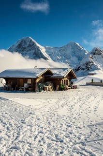 Wooden chalet and ski slope, with views of the Eiger, Mönch and Tschuggen, Grindelwald, Bernese