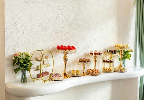 Elegant dessert display featuring luxurious gold stands adorned with assorted pastries. Aesthetic