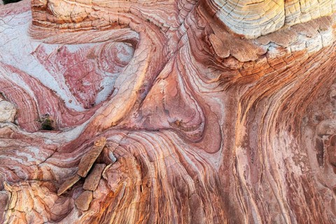 Discover the intricate patterns and vibrant colors of the swirling rock formations in Vermilion