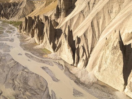 Rugged, steep cliffs rise dramatically from the ground, molded over time by natural erosion in