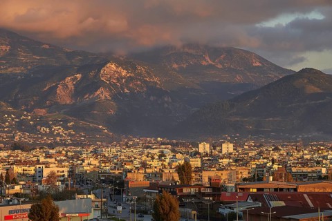 Panorama of a city against a mountainous backdrop with dramatic clouds, Patras, Peloponnese, Greece