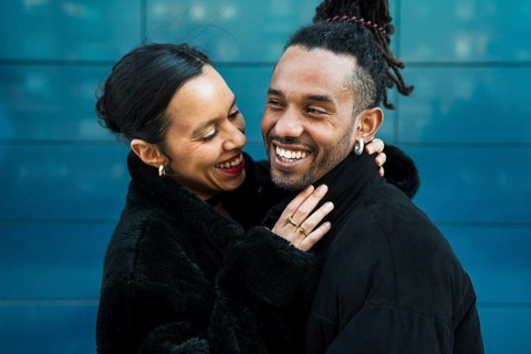 A happy multicultural couple embraces and smiles lovingly at each other, symbolizing joy and