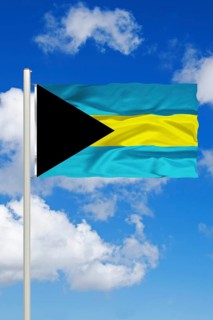 National flag of the Bahamas in front of cumulus clouds and blue sky, Studio
