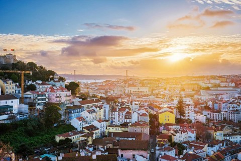 Breathtaking sunset over Lisbon with views of the Carmo Convent ruins and 25th of April Bridge from