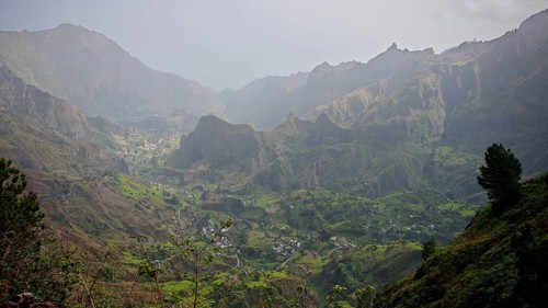 Panoramic, spectacular view over a valley with a winding path, hiking trail and mountains in the
