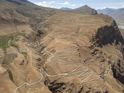 A stunning aerial view captures the winding roads of Spiti Valley, India, showcasing the rugged,