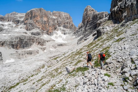 Two mountaineers on a hiking trail to Sella della Tosa, mountainous landscape in the Brenta