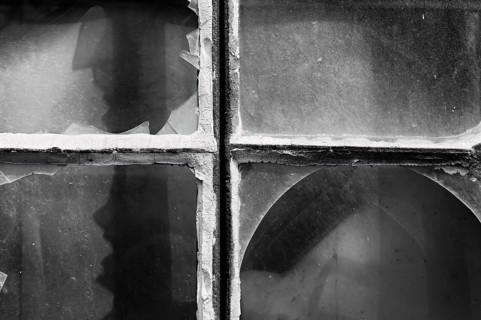 Broken window panes with a human-like screaming face
