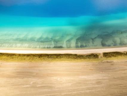 A breathtaking aerial view of Pangong Tso lake in Ladakh with vibrant blue waters, sandy shores,
