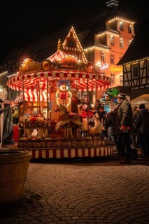 Evening scene with illuminated carousel and people at a Christmas market, Christmas market Calw,