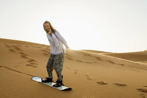 Young woman with snowboard in the sand dunes, near Merzouga, Meknès-Tafilalet region, Erg Chebbi,